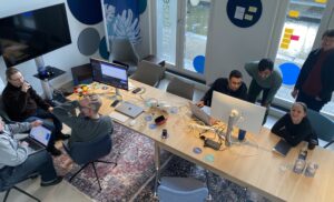 Groepjes mensen rondom computers in overleg