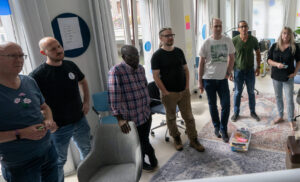 Een groepje medewerkers van TrailBlazers staand rondom een flipover tijdens een TrailBlazers-kwartaalmeeting op 20/8/2024.