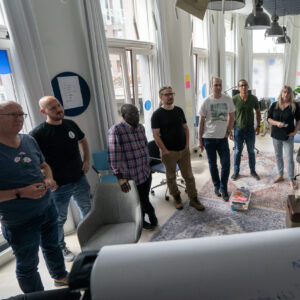 Een groepje medewerkers van TrailBlazers staand rondom een flipover tijdens een TrailBlazers-kwartaalmeeting op 20/8/2024.